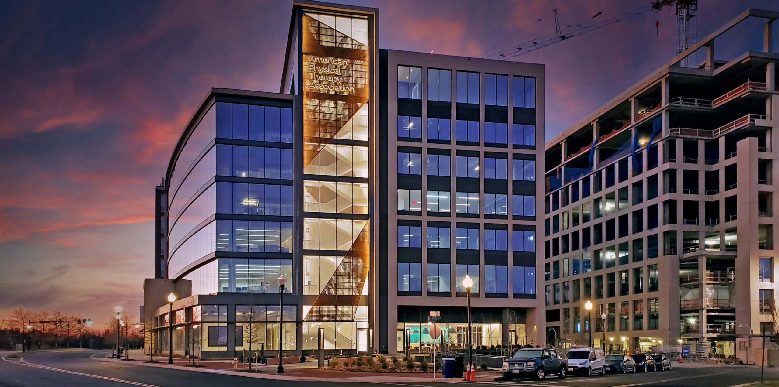 The new headquarters of the American Physical Therapy Association (APTA) at dusk. Synergi's custom design perforated metal guardrail can be seen at center