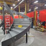 a curved stair structure is being fabricated in a shop